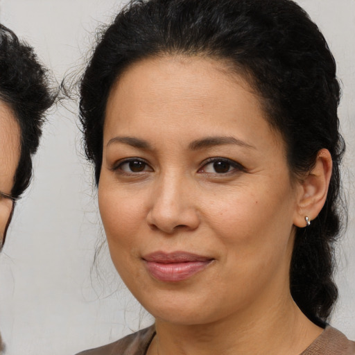 Joyful latino adult female with medium  brown hair and brown eyes