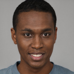 Joyful black young-adult male with short  brown hair and brown eyes