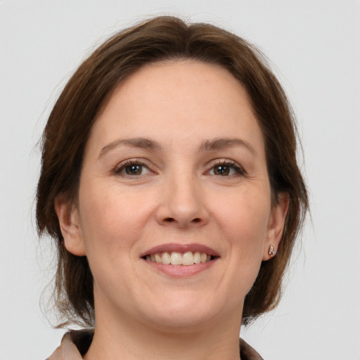 Joyful white adult female with medium  brown hair and grey eyes