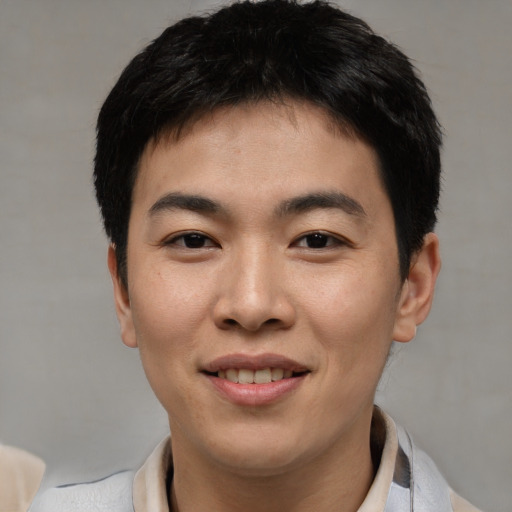 Joyful asian young-adult male with short  black hair and brown eyes