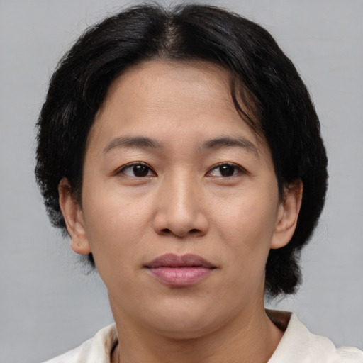 Joyful asian adult female with medium  brown hair and brown eyes