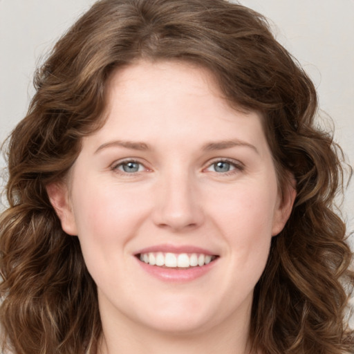 Joyful white young-adult female with long  brown hair and blue eyes