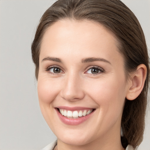 Joyful white young-adult female with medium  brown hair and grey eyes