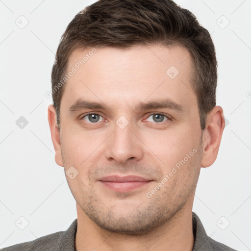 Joyful white young-adult male with short  brown hair and grey eyes