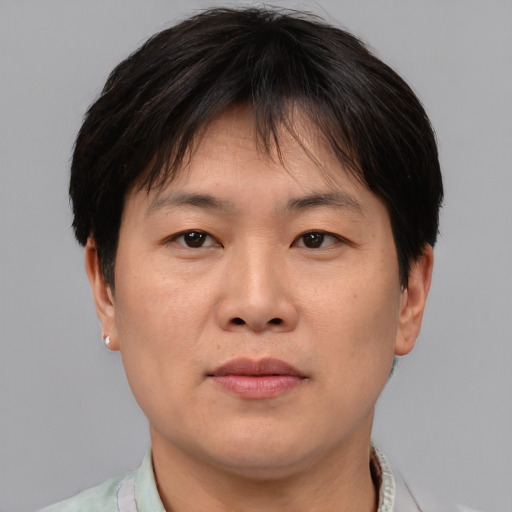 Joyful asian adult male with short  brown hair and brown eyes