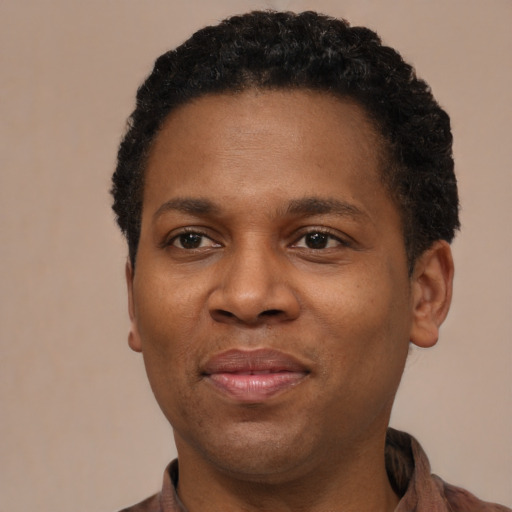Joyful black young-adult male with short  brown hair and brown eyes