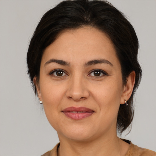 Joyful latino adult female with medium  brown hair and brown eyes
