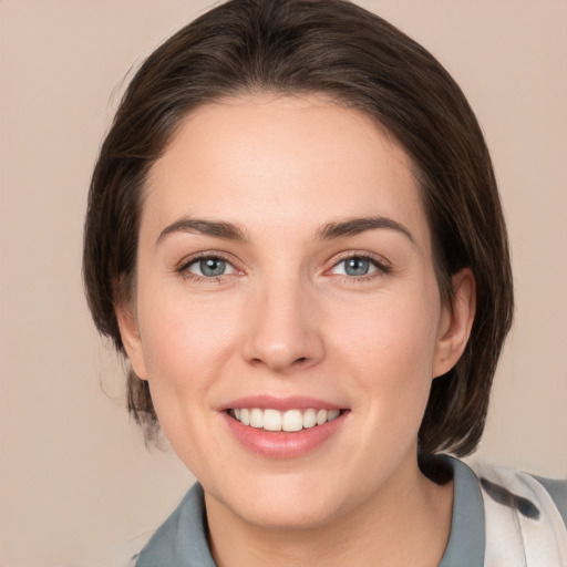 Joyful white young-adult female with medium  brown hair and grey eyes