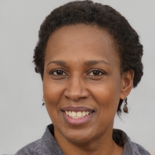 Joyful black adult female with short  brown hair and brown eyes