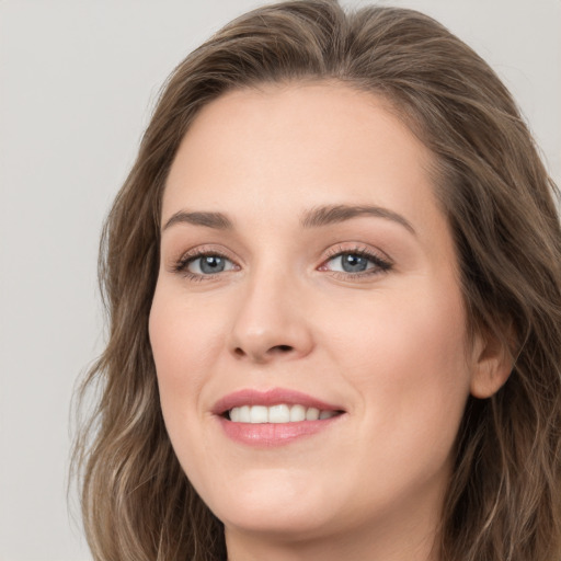 Joyful white young-adult female with long  brown hair and blue eyes