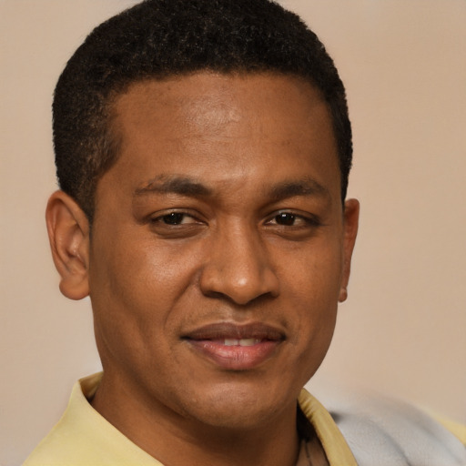 Joyful black adult male with short  brown hair and brown eyes