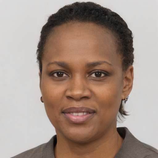 Joyful black young-adult female with short  black hair and brown eyes