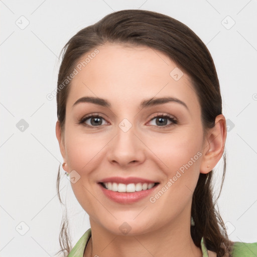 Joyful white young-adult female with long  brown hair and grey eyes