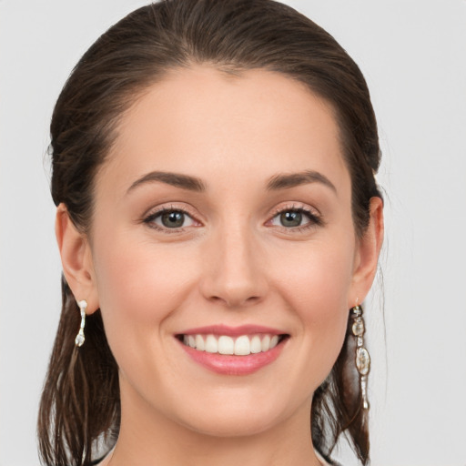 Joyful white young-adult female with medium  brown hair and grey eyes