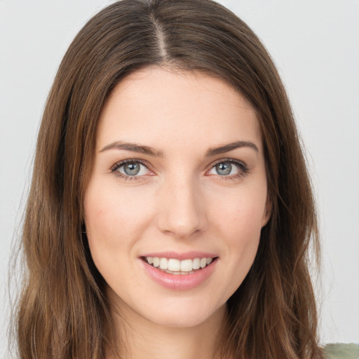 Joyful white young-adult female with long  brown hair and green eyes