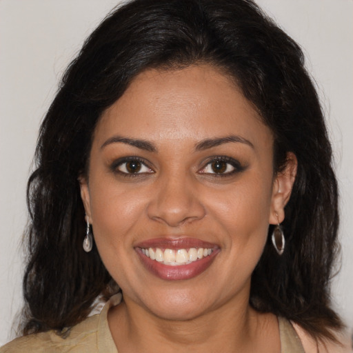 Joyful black young-adult female with long  brown hair and brown eyes