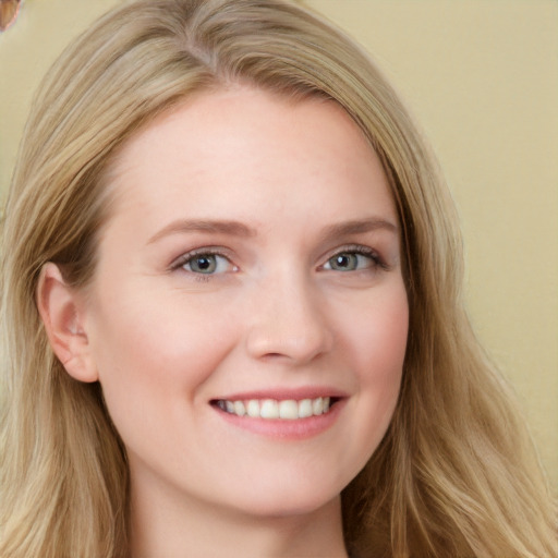 Joyful white young-adult female with long  brown hair and blue eyes