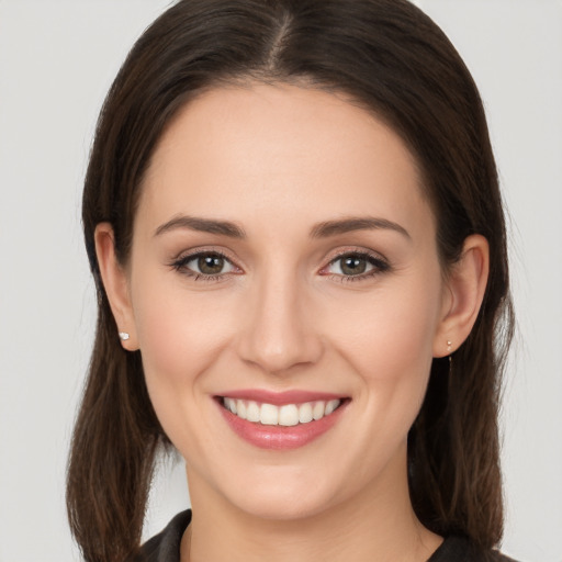 Joyful white young-adult female with long  brown hair and brown eyes