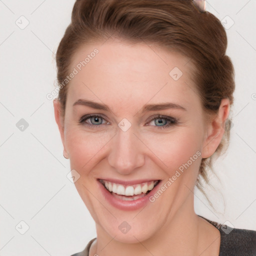 Joyful white young-adult female with short  brown hair and blue eyes