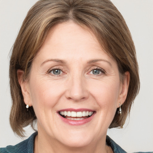 Joyful white adult female with medium  brown hair and grey eyes