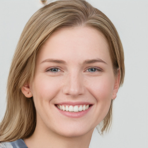 Joyful white young-adult female with medium  brown hair and blue eyes