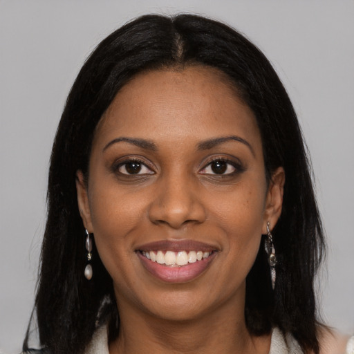 Joyful black young-adult female with long  black hair and brown eyes