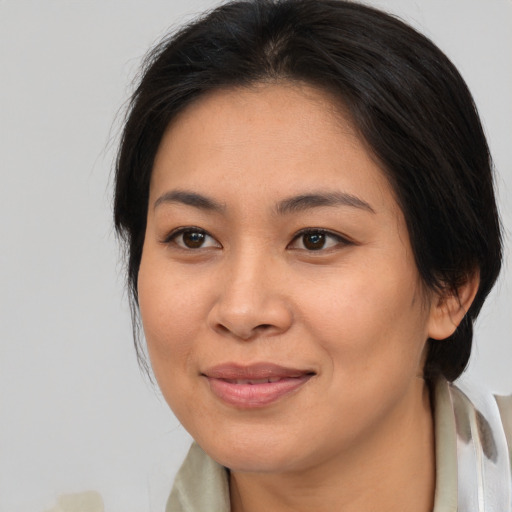 Joyful asian young-adult female with medium  brown hair and brown eyes