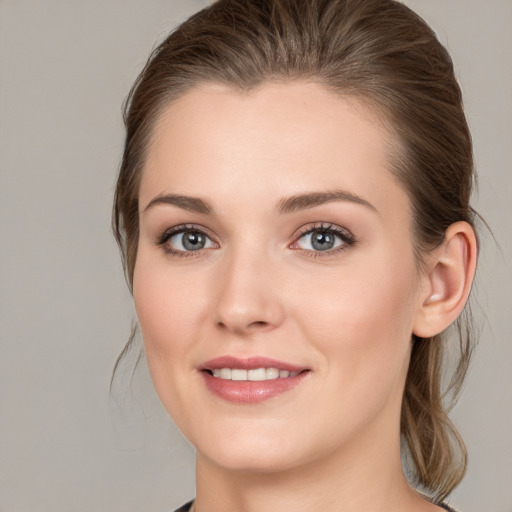 Joyful white young-adult female with medium  brown hair and grey eyes