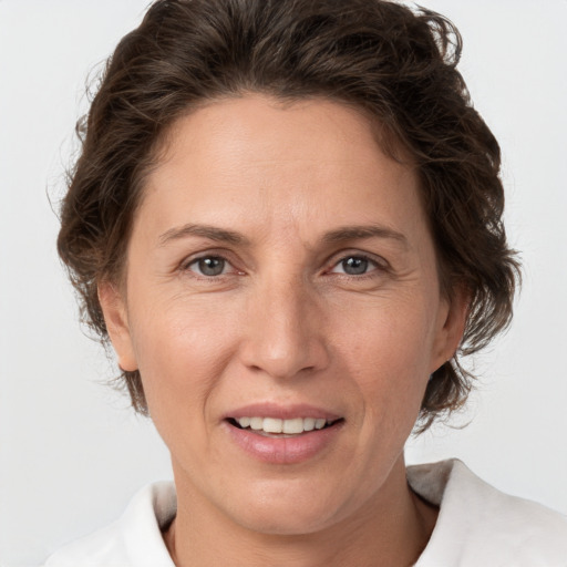 Joyful white adult female with medium  brown hair and grey eyes