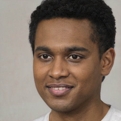 Joyful black young-adult male with short  brown hair and brown eyes