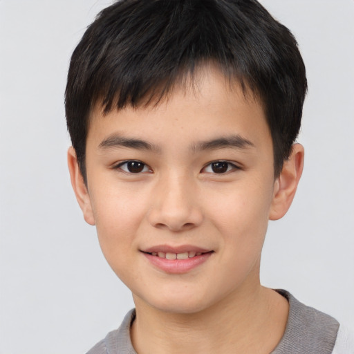 Joyful asian child male with short  brown hair and brown eyes