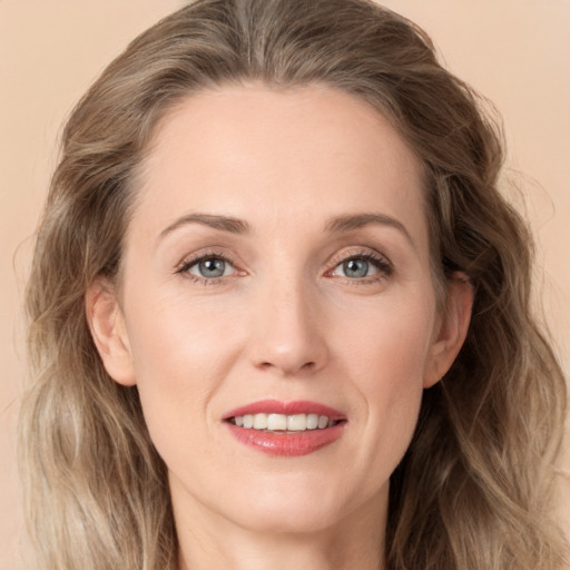 Joyful white adult female with long  brown hair and grey eyes