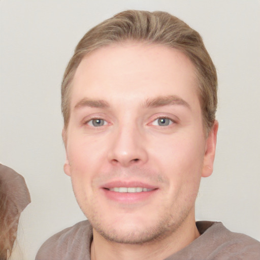 Joyful white young-adult male with short  brown hair and grey eyes