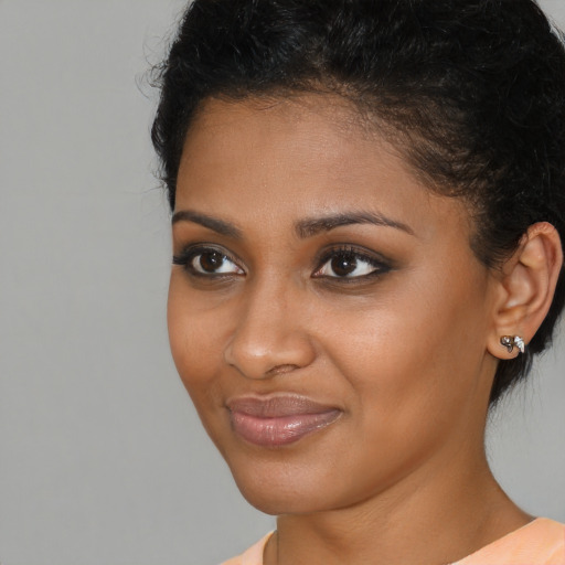 Joyful black young-adult female with short  brown hair and brown eyes