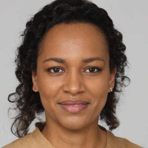 Joyful black young-adult female with long  brown hair and brown eyes
