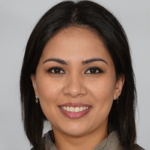 Joyful latino young-adult female with long  brown hair and brown eyes