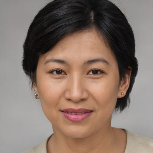 Joyful asian adult female with medium  brown hair and brown eyes