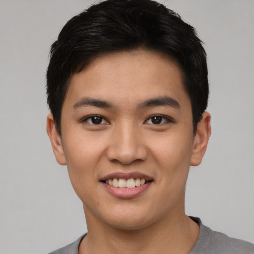 Joyful asian young-adult male with short  black hair and brown eyes