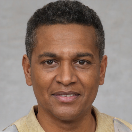 Joyful black adult male with short  brown hair and brown eyes