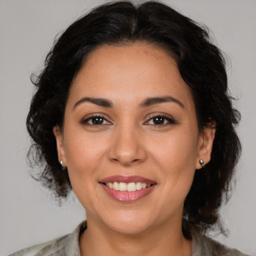 Joyful latino young-adult female with medium  brown hair and brown eyes