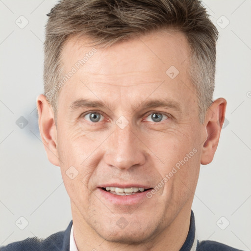 Joyful white adult male with short  brown hair and grey eyes