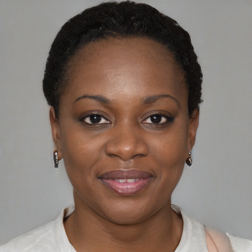 Joyful black young-adult female with short  black hair and brown eyes