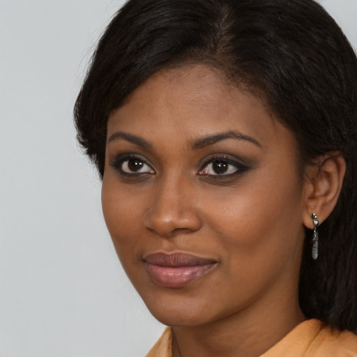 Joyful black young-adult female with long  brown hair and brown eyes