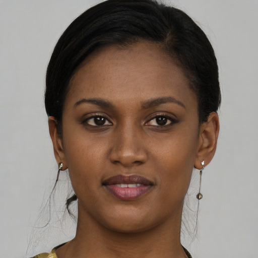 Joyful black young-adult female with long  brown hair and brown eyes