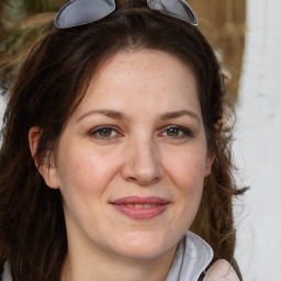 Joyful white adult female with long  brown hair and grey eyes