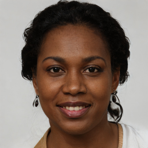 Joyful black young-adult female with medium  brown hair and brown eyes