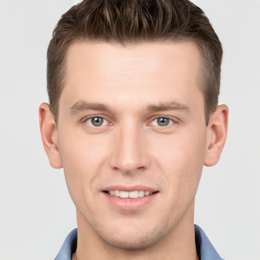 Joyful white young-adult male with short  brown hair and grey eyes