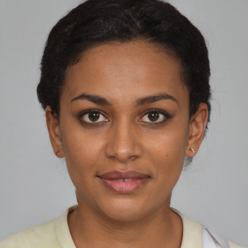 Joyful black young-adult female with short  brown hair and brown eyes