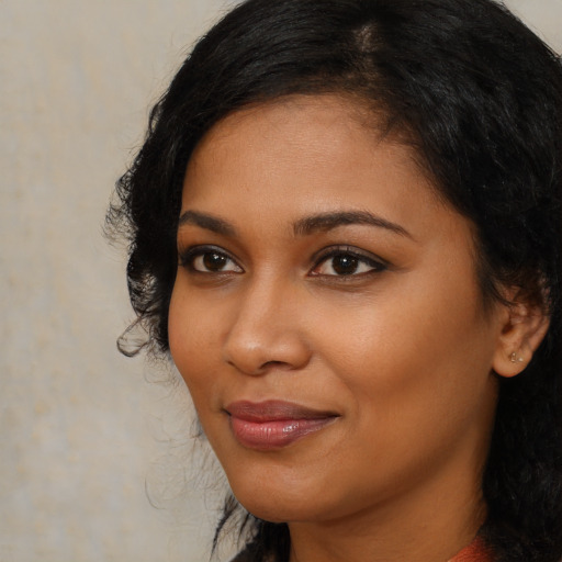 Joyful black young-adult female with long  brown hair and brown eyes
