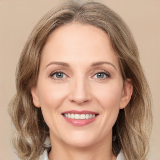 Joyful white adult female with medium  brown hair and green eyes